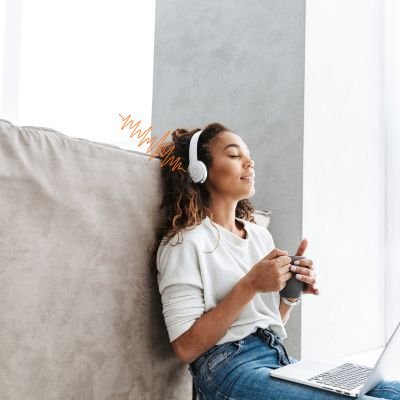 JBL Tune 720BT: e Tune 520BT Uma Solução Ideal para Quem Busca Som de Qualidade Sem Incomodar Outras Pessoas 1 mulher com fone de ouvido JBL Tune 720BT centada no chao da sala